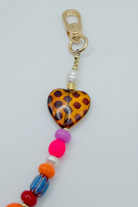 Colorful beaded keychain with a heart-shaped tag on a light gray background