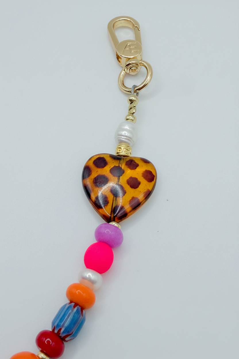 Colorful beaded keychain with a heart-shaped tag on a light gray background
